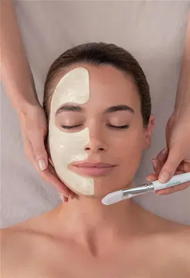 a woman applying a moisturizing mask on her face with a cosmetic wand at Winelands Golf Lodges 17 in Stellenbosch