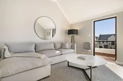 a living room with a couch and a mirror at Winelands Golf Lodges 20 in Stellenbosch