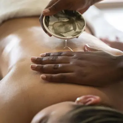 a woman getting a massage in front of a mirror at Winelands Golf Lodges 22 in Stellenbosch