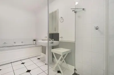 a white bathroom with a tub and a sink at Winelands Golf Lodges 22 in Stellenbosch