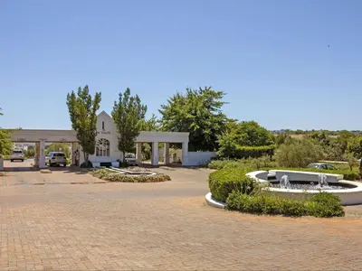 a building with a fountain in the middle of a driveway at Winelands Golf Lodges 30 in Stellenbosch