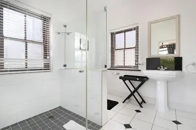 a white bathroom with a sink and a shower at Winelands Golf Lodges 30 in Stellenbosch