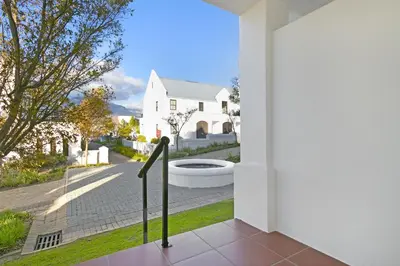 a balcony with a view of a house at Winelands Golf Lodges 37 in Stellenbosch