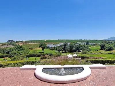 a fountain in a garden with a view of a field at Winelands Golf Lodges 37 in Stellenbosch