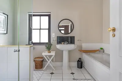 a bathroom with a sink and a tub and a mirror at Winelands Golf Lodges 38 in Stellenbosch