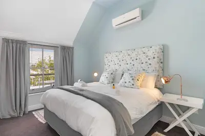 a bedroom with a large bed and a window at Winelands Golf Lodges 40 in Stellenbosch