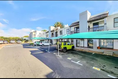 a yellow jeep parked in a parking lot with umbrellas at One Bedroom Loevenstein in Tygerberg Hills