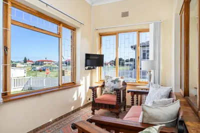 a living room with a large window and a tv at The Kleinmond Cottage in Kleinmond