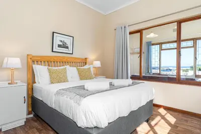 a bedroom with a large bed and a window at The Kleinmond Cottage in Kleinmond