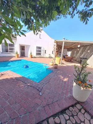 a swimming pool in the middle of a yard at Stunning 3 Bedroom beach house in Bloubergstrand in Cape Town