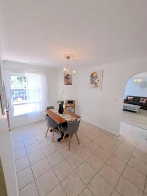 a living room with a table and a dining room at Stunning 3 Bedroom beach house in Bloubergstrand in Cape Town