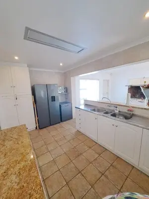 a kitchen with white cabinets and a blue refrigerator at Stunning 3 Bedroom beach house in Bloubergstrand in Cape Town