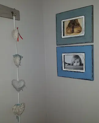 a picture of a baby in a picture frame on a wall at Strandloper Apartments in Hermanus
