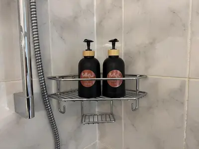 two black bottles on a shelf in a bathroom at Serene waterfront escape! Luxury, King bed! in Durbanville