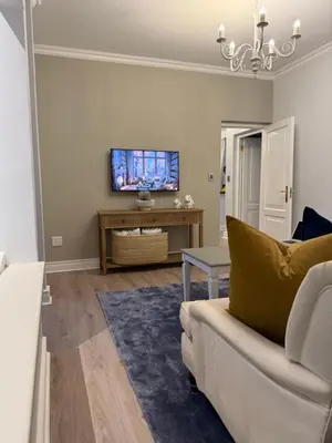 a living room with a couch and a tv at Franschoek Lermitage Villa 33 Three Bedroom Lake View in Franschhoek