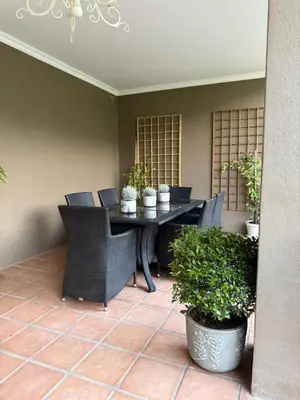 a patio with a table and chairs and plants at Franschoek Lermitage Villa 33 Three Bedroom Lake View in Franschhoek