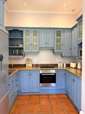 a kitchen with blue cabinets and an oven at Franschoek Lermitage Villa Two Bedroom Lake View in Franschhoek