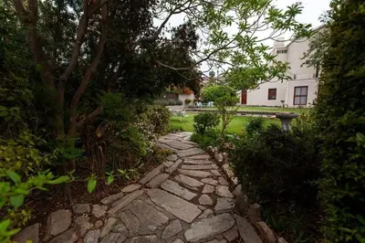 a stone path in a garden with a house in the background at The Habit Apartments in Worcester