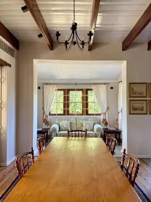 a dining room with a large table and a couch at Sevilo Farmhouse in Stellenbosch