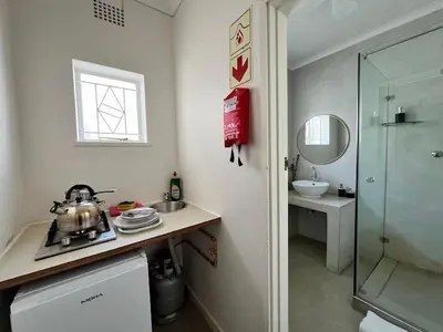 a bathroom with a sink and a glass shower at Avignon Guesthouse in Worcester