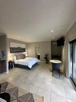 a large bedroom with a bed and a table at Best Rest Somerset 3 in Somerset West