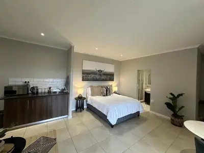 a large bedroom with a bed and a kitchen at Best Rest Somerset 3 in Somerset West