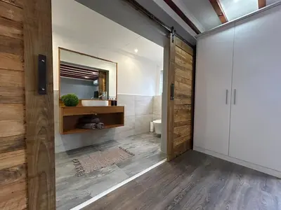 a bathroom with a toilet and a sink and a mirror at Val Mor country house in Paarl