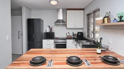 a kitchen with a wooden counter top with black bowls on it at Happy Days in Paarl