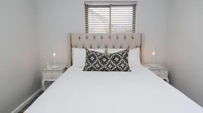 a bedroom with a large white bed with two night stands at Happy Days in Paarl
