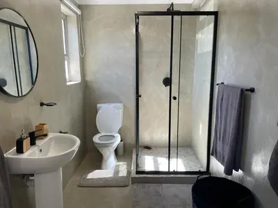 a bathroom with a shower and a toilet and a sink at Apartment in Gordon's Bay in Gordonʼs Bay