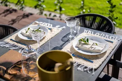 a table with plates of food and glasses on it at LEO Sky Farm Cottages in Simondium