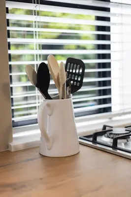 a white coffee cup filled with utensils on a counter at 44 on Mountain Drive in Hermanus