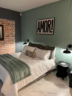 a bedroom with a large bed with a sign on the wall at Southern Comfort Guest House in Bellville