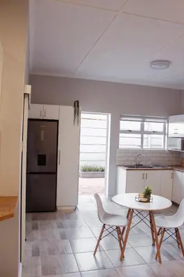 a kitchen with a table and chairs and a refrigerator at Sage And Vine Studio in Worcester