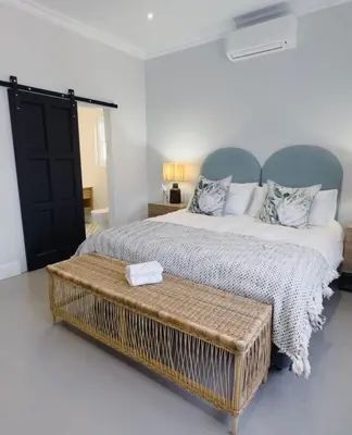 a bedroom with a large bed with a coffee table at Stunning Home in Hermanus Town Centre in Hermanus