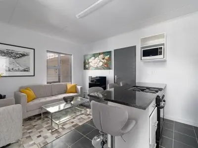 a kitchen and living room with a couch and a table at 4 Essex Street Apartment in Cape Town