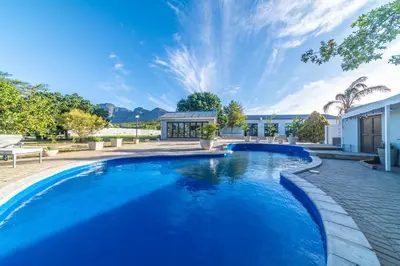 a swimming pool in a yard with a house at LEO Sky Guest House in Simondium