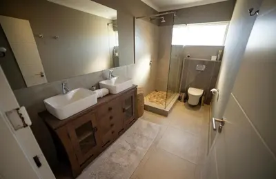 a bathroom with two sinks and a shower at Close to the sea and sea path in Hermanus