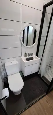 a bathroom with a white toilet and a mirror at Blouberg Luxury Studio Apartment in Cape Town