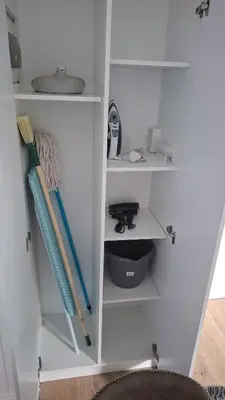 a white book shelf with some items on it at Blouberg Luxury Studio Apartment in Cape Town