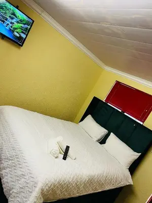 a bedroom with a bed with a remote control on it at AFRICAN HAVEN GUEST HOUSE BnB GOODWOOD in Cape Town