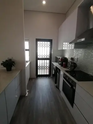 a kitchen with a sink and a stove top oven at Sandown Sun in Cape Town