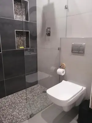 a bathroom with a toilet and a glass shower at Sandown Sun in Cape Town