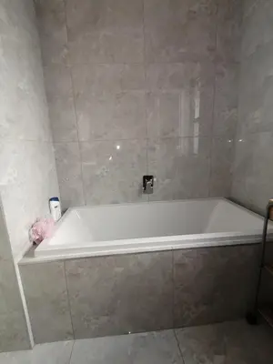 a white bath tub in a bathroom at Sandown Sun in Cape Town