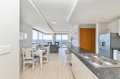 a kitchen and dining room with a table and chairs at Horizon Bay 206 by HMH in Cape Town