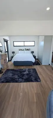a bedroom with a bed and a rug on the floor at Glorious44 in Cape Town