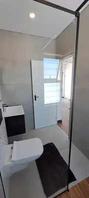 a bathroom with a white toilet and a sink at Glorious44 in Cape Town