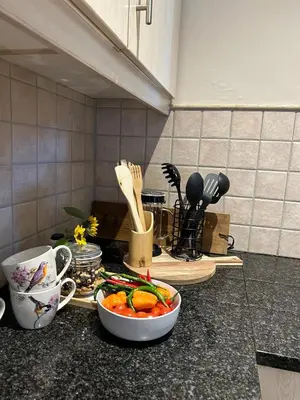 a kitchen counter with a bowl of vegetables and utensils at Dottie's charming cottage two bedroom apartment and workspace in Paarl