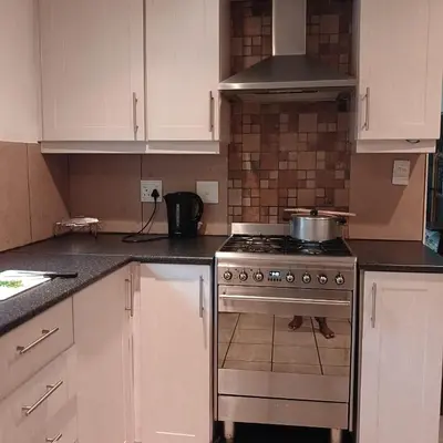 a kitchen with a stove and white cabinets at Tripple S in Bellville