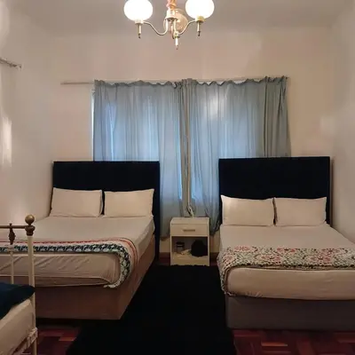 a bedroom with two beds and a chandelier at Tripple S in Bellville